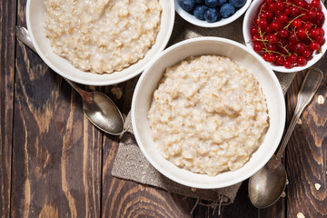 homemade oatmeal and berries on wooden table, top view