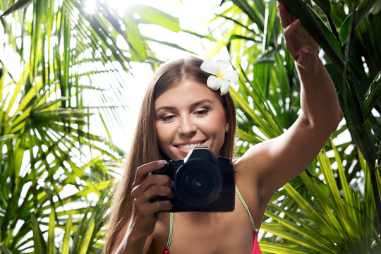 portrait of nice young woman is taking picture in the  jungle