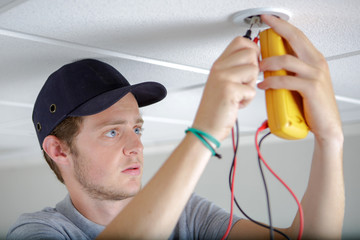 Man testing bulb holder with multimeter
