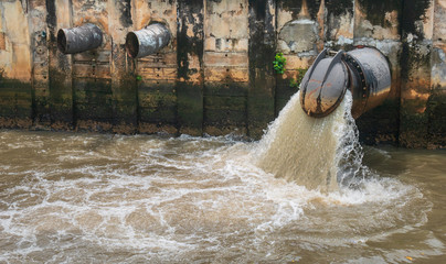 The large drain of the city is draining the wastewater into the canal, flowing into the sea, as a result of environmental issues in environment and ecology concept.