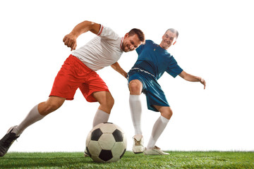 Fototapeta na wymiar Football players tackling for the ball over white background. Professional football soccer players in motion isolated white studio background. Fit jumping men in action, jump, movement at game.