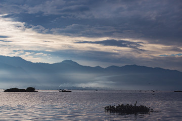 floating village and transparent light passes through the morning fog and clouds over lake Inle, burma, myanmar