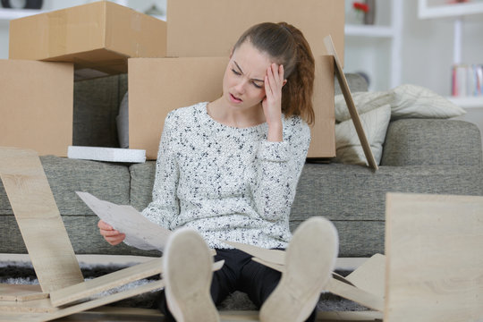 frustrated woman putting together self assembly furniture