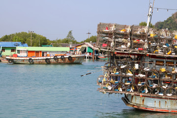 Local fishing boats with fish trap cages on a boat in the river along the coast