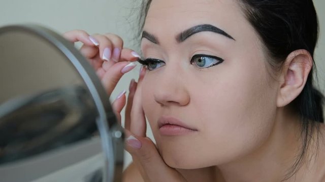 Woman attach false eyelashes to herself in slow motion HD