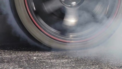 Drag racing car burns rubber off its tires in preparation for the race