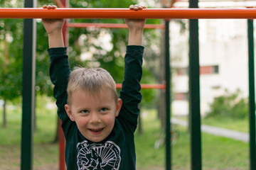 A little boy on the bar. Physical activity and development of the child.