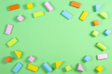Colorful wooden blocks on green background