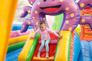 A cheerful child plays in an inflatable castle