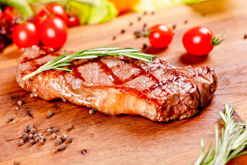 Grilled beef steak on wooden cutting board. Close up