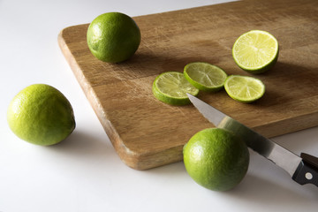 Limas y limones cortados en una tabla de madera