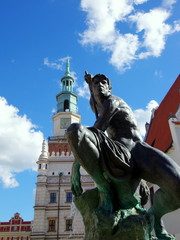 Mars, posąg greckiego boga a w tle wieża poznańskiego Ratusza