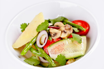 Vegetable salad with parmesan cheese on white plate. Close up