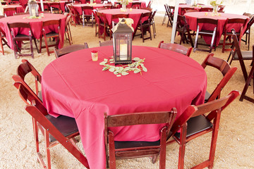 Rustic red round wedding table decorated with a night lamp and flowers 