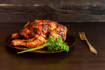 baked chicken on a dark wooden background.