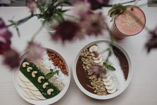 Artistically arranged bowls of yogurt with fruit and nuts