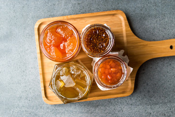 Various Jar of Fruit Jams Fig, Quince, Bergamot Citrus, Watermelon on Wooden Tray / Marmalade