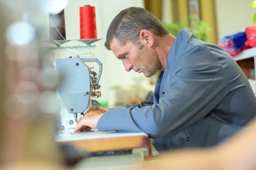 Middle aged man using sewing machine