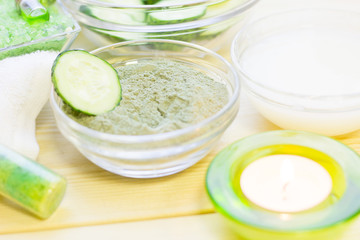 Cucumber home spa and hair care concept. Sliced cucumber, bottles of oil, sea salt, bathroom towel. White board background