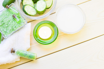 Cucumber home spa and hair care concept. Sliced cucumber, bottles of oil, sea salt, bathroom towel. White board background