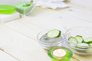 Cucumber home spa and hair care concept. Sliced cucumber, bottles of oil, sea salt, bathroom towel. White board background