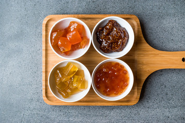 Various Ceramic bowl of Fruit jams Fig, Quince, Bergamot Citrus, Watermelon in wooden tray / Marmalade