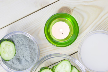 Cucumber home spa and hair care concept. Sliced cucumber, bottles of oil, sea salt, bathroom towel. White board background