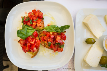 Radda Italy July 2nd 2015 : Cheese, honey and pear with a side of tomato bruschetta in Radda, Tuscany, Italy