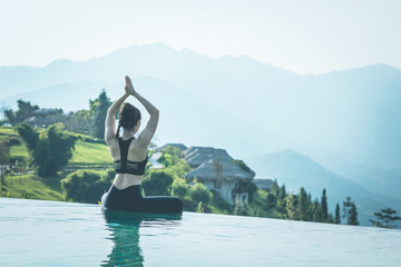 Beautiful Attractive Asian woman practice yoga Lotus pose on the pool above the Mountain peak in the morning in front of beautiful nature views in SAPA vietnam,Feel so comfortable and relax in holiday