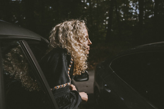Woman with bleached hair leaning out of car window