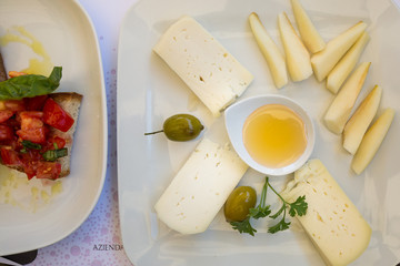 Radda Italy July 2nd 2015 : Cheese, honey and pear with a side of tomato bruschetta in Radda, Tuscany, Italy