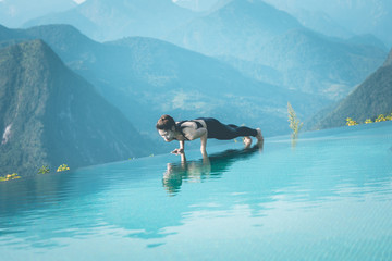 Beautiful Attractive Asian woman practice yoga Plank or Phalakasana Pose on the pool above the Mountain peak in the morning in front of beautiful nature views in SAPA vietnam,Feel so comfortable