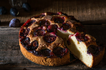 Homemade plum pie on the old wooden background. Still life of food. plum tart. Autumn harvest. Old fashion cuisine. Portion of pie. Plum bakery. Rustic open pie. Winter pie. New York pie.