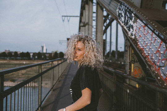 Woman with bleached hair standing on bridge