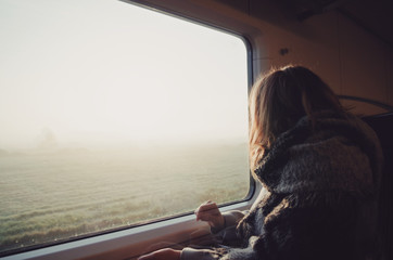 Girl in train looking through window