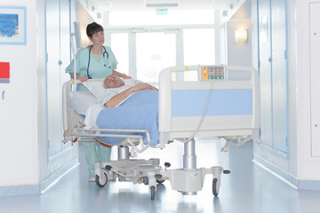 portrait of nurse pushing stretcher in hospital