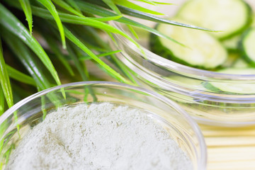 Cucumber home spa and hair care concept. Sliced cucumber, bottles of oil, sea salt, bathroom towel. White board background