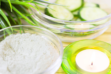 Cucumber home spa and hair care concept. Sliced cucumber, bottles of oil, sea salt, bathroom towel. White board background