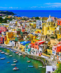 View of the Port of Corricella with lots of colorful houses on a sunny day in Procida Island, Italy. - 225553403