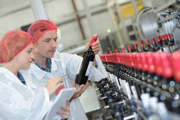 portrait of cheerful experts in wine factory
