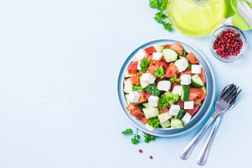 Cucumber feta tomato salad with olive oil dresssing. Top view, space for text.