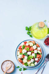 Cucumber feta tomato salad with olive oil dresssing. Top view, space for text.