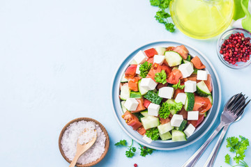 Cucumber feta tomato salad with olive oil dresssing. Top view, space for text.