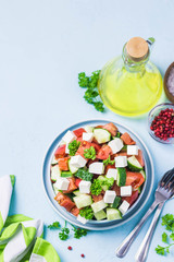 Cucumber feta tomato salad with olive oil dresssing. Top view, space for text.