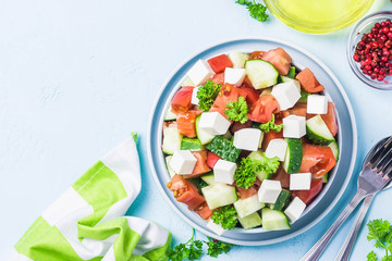 Cucumber feta tomato salad with olive oil dresssing. Top view, space for text.