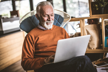 Senior businessman working on laptop at his workplace.