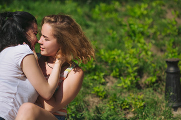Fototapeta premium Two best frinds have fun in the park. Two girl almost kiss each other.