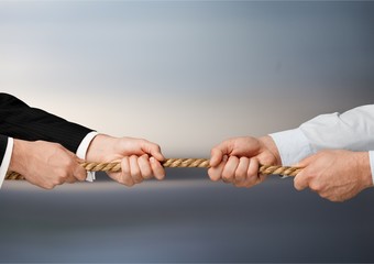 Tug war, two businessman pulling a rope