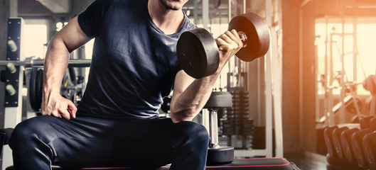 man pickup dumbell in gym . exercise with work out program for healthy