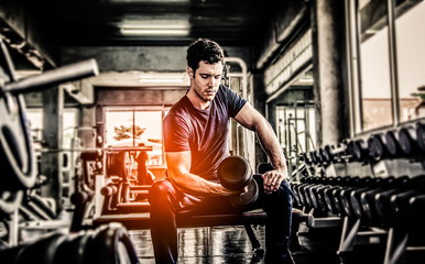 man pickup dumbell in gym . exercise with work out program for healthy